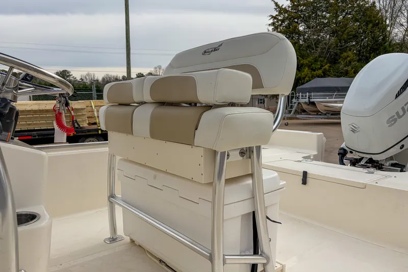 Slide: The Image of 2026 Bulls Bay 2400 boat interior with cushioned seating and Suzuki outboard motor. - 5