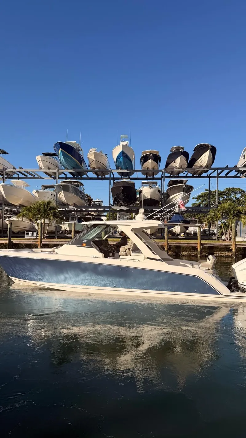 Slide: The Image of 2023 Tiara Sport 34 LS boat on water near a marina. - 10