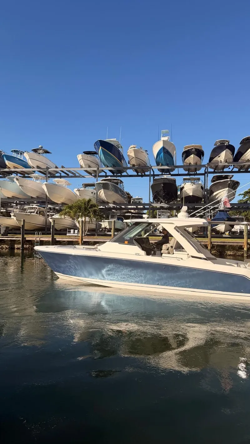 Slide: The Image of 2023 Tiara Sport 34 LS boat on water near boat rack. - 11
