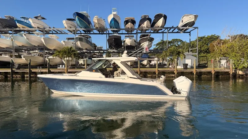 Slide: The Image of 2023 Tiara Sport 34 LS boat on water near boat storage. - 13