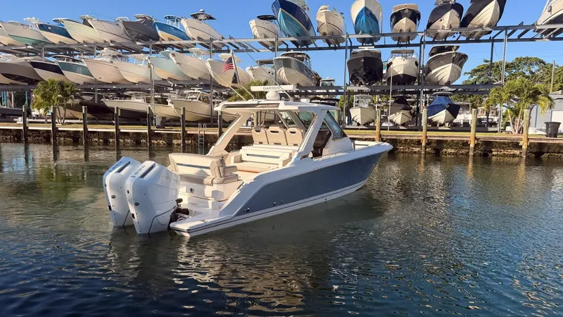 Slide: The Image of 2023 Tiara Sport 34 LS boat in water near boat rack. - 3