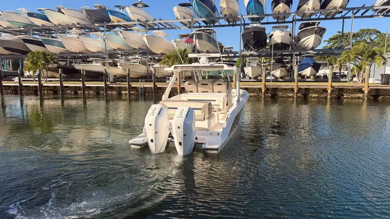 Slide: The Image of 2023 Tiara Sport 34 LS boat in water near boat storage. - 7