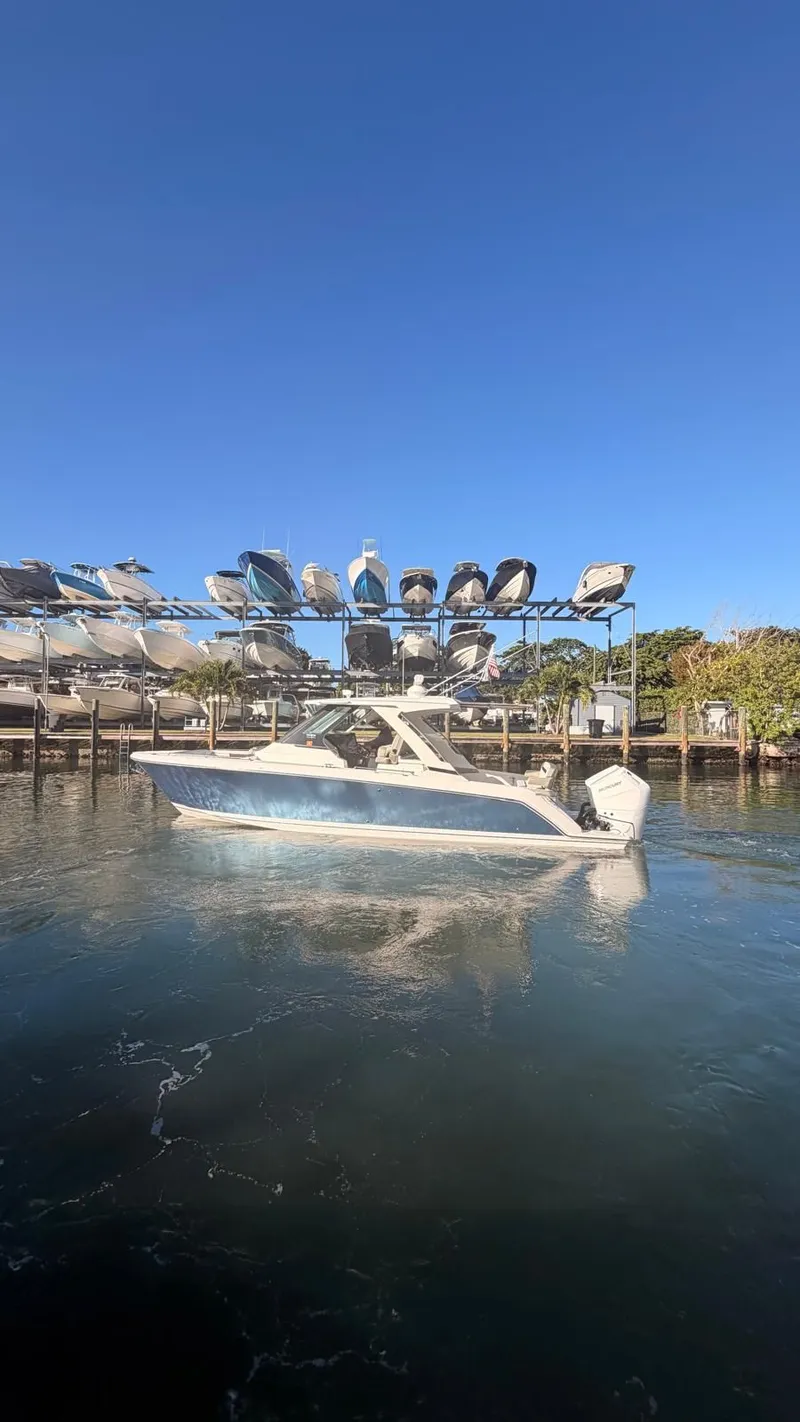 Slide: The Image of 2023 Tiara Sport 34 LS boat on water near a marina. - 8