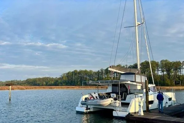 Slide: The Image of 2023 Fountaine Pajot Isla 40 catamaran docked on a serene lake with trees. - 11