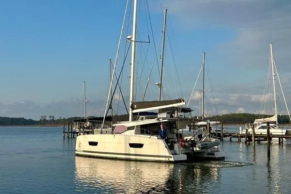 Slide: The Image of 2023 Fountaine Pajot Isla 40 catamaran sailing in a serene marina setting. - 13