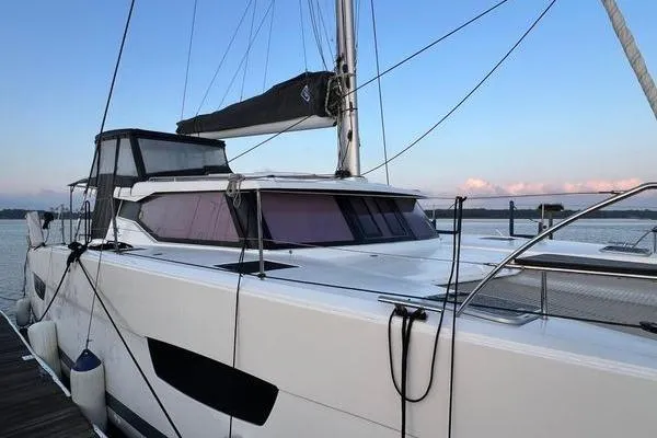 Slide: The Image of 2023 Fountaine Pajot Isla 40 catamaran docked at sunset, showcasing sleek design and modern features. - 2