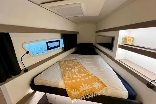 Slide: The Image of 2023 Fountaine Pajot Isla 40 cabin interior with bed, window, and decorative accents. - 24