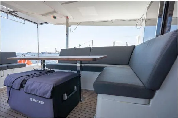 Slide: The Image of 2023 Fountaine Pajot Isla 40 yacht interior with seating and table, featuring a Dometic cooler. - 48