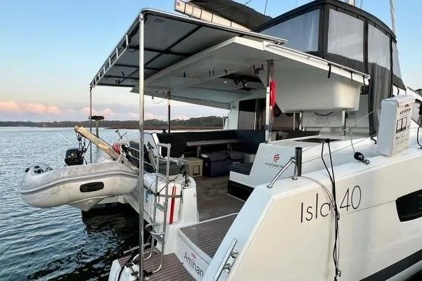 Slide: The Image of 2023 Fountaine Pajot Isla 40 catamaran docked, featuring spacious deck and inflatable dinghy. - 6