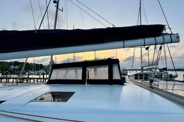 Slide: The Image of 2023 Fountaine Pajot Isla 40 catamaran docked at sunset, showcasing sleek design. - 63
