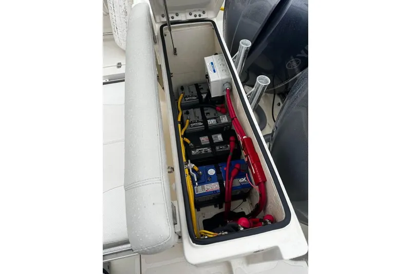 Slide: The Image of 2014 Pursuit OS 345 Offshore boat battery compartment with multiple batteries and wiring. - 29