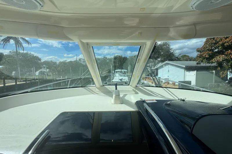 Slide: The Image of Interior view of 2014 Pursuit OS 345 Offshore boat with clear windshield and sunny sky. - 39