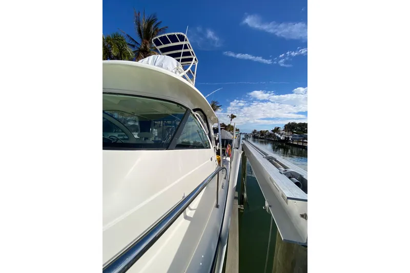 Slide: The Image of 2014 Pursuit OS 345 Offshore boat docked under a clear blue sky. - 4