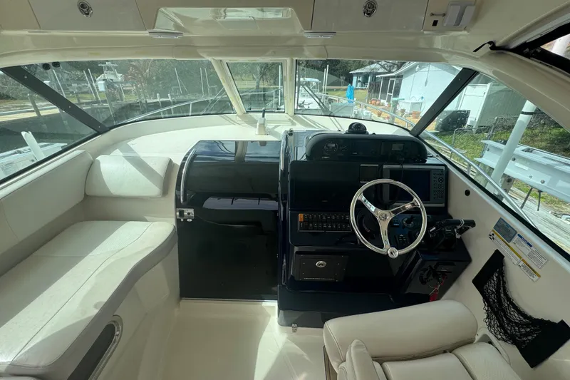 Slide: The Image of 2014 Pursuit OS 345 Offshore boat interior with steering wheel and seating area. - 42