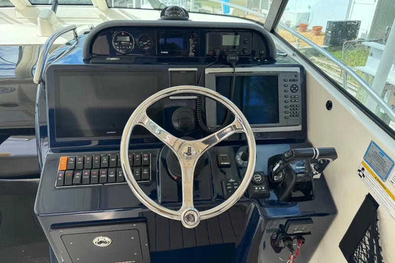 Slide: The Image of Control panel of a 2014 Pursuit OS 345 Offshore boat with steering wheel and navigation equipment. - 43