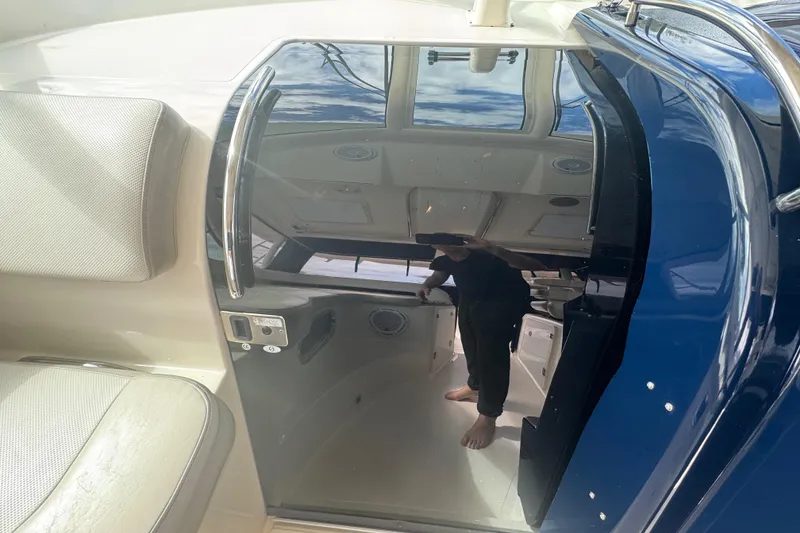 Slide: The Image of 2014 Pursuit OS 345 Offshore boat interior with reflective glass door and cushioned seating. - 44