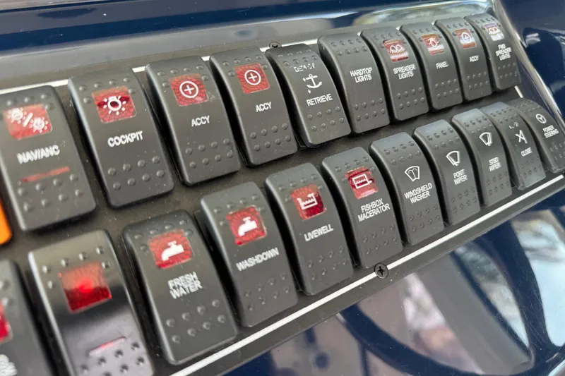 Slide: The Image of Control panel of a 2014 Pursuit OS 345 Offshore boat with labeled switches. - 46