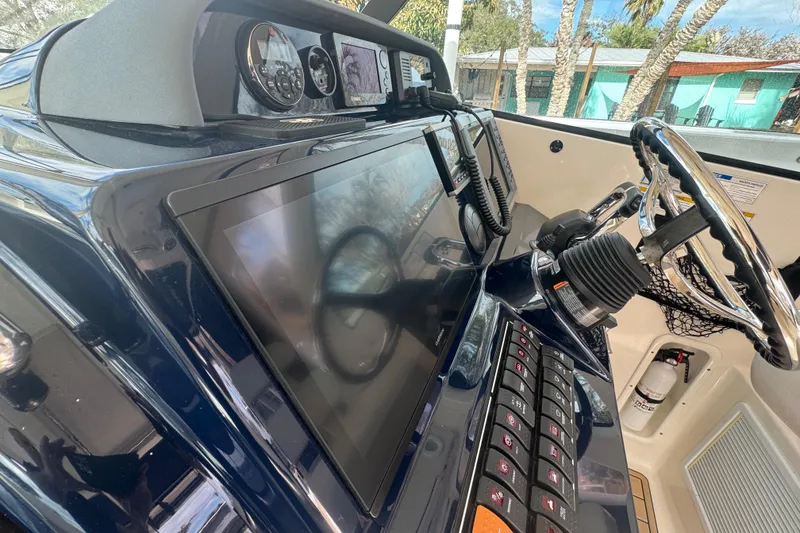 Slide: The Image of 2014 Pursuit OS 345 Offshore boat dashboard with advanced navigation controls and steering wheel. - 47