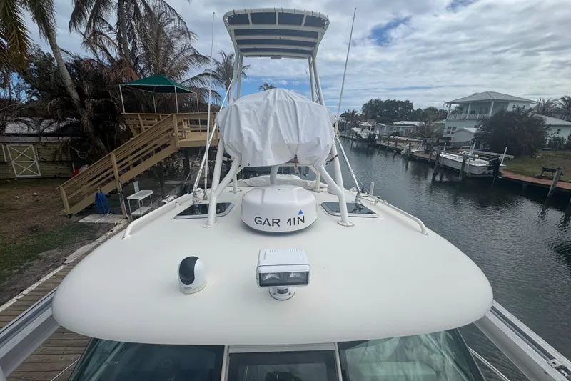 Slide: The Image of 2014 Pursuit OS 345 Offshore boat docked by a canal with palm trees. - 5