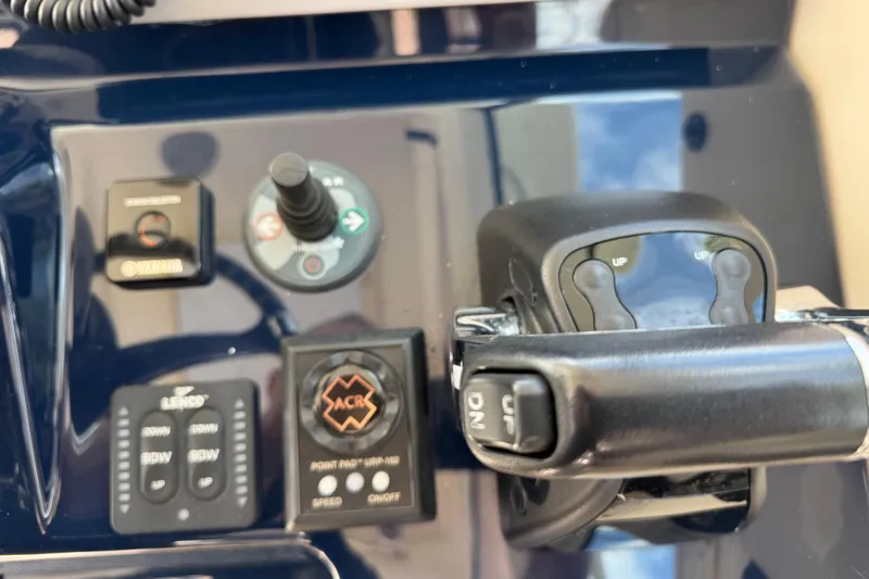 Slide: The Image of Control panel of 2014 Pursuit OS 345 Offshore boat with various switches and levers. - 51