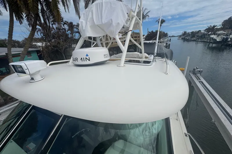 Slide: The Image of 2014 Pursuit OS 345 Offshore boat with radar, docked by palm trees. - 6