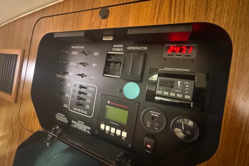 Slide: The Image of Control panel of a 2014 Pursuit OS 345 Offshore boat, featuring power and air conditioning controls. - 62