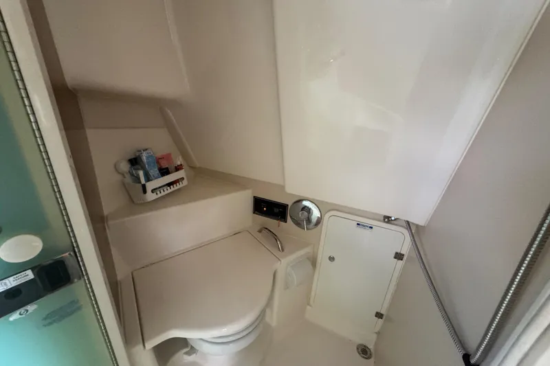 Slide: The Image of 2014 Pursuit OS 345 Offshore boat bathroom with compact design and storage. - 65