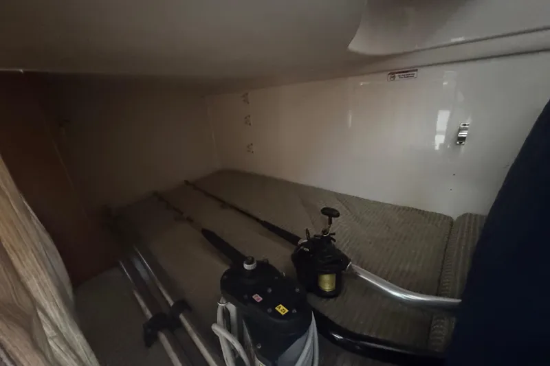 Slide: The Image of 2014 Pursuit OS 345 Offshore cabin interior with fishing gear storage. - 69