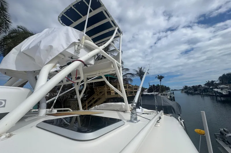 Slide: The Image of 2014 Pursuit OS 345 Offshore boat docked by a scenic canal under a cloudy sky. - 8