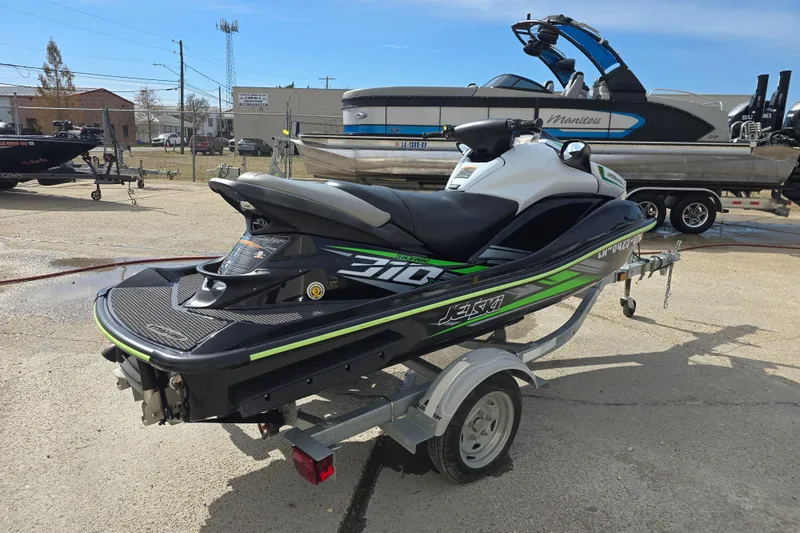 Slide: The Image of 2016 Kawasaki Jetski Ultra 310X on trailer, parked outdoors in a marina setting. - 1