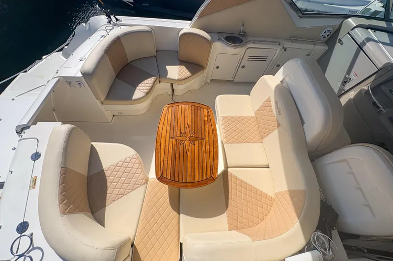 Slide: The Image of 2008 Sea Ray 380 Sundancer cockpit with beige seating and wooden table. - 42