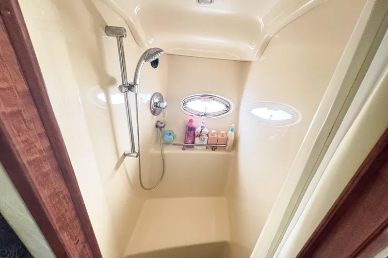 Slide: The Image of Shower area in 2008 Sea Ray 380 Sundancer yacht with toiletries and porthole window. - 64