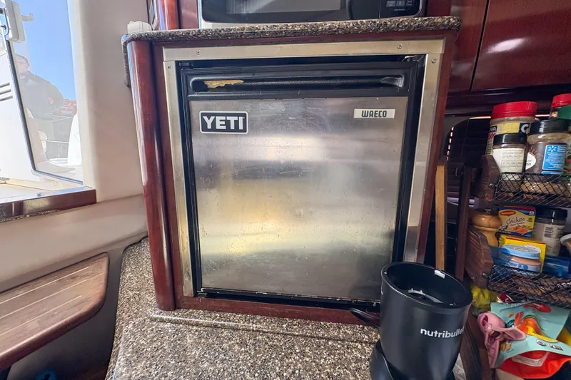 Slide: The Image of Compact kitchen area on a 2008 Sea Ray 380 Sundancer yacht with Yeti fridge. - 76