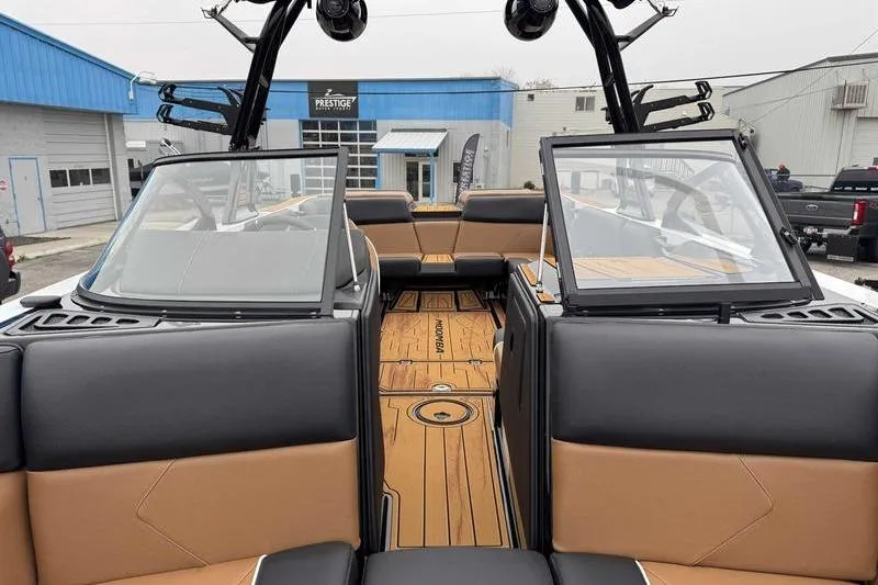 Slide: The Image of 2026 Moomba Tykon boat interior with tan and black seating, docked at a marina. - 10