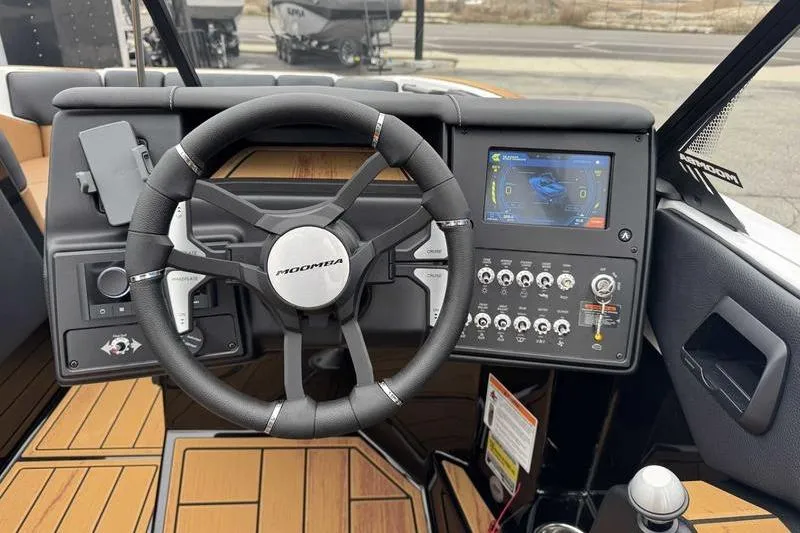 Slide: The Image of 2026 Moomba Tykon boat dashboard with steering wheel and control panel. - 13