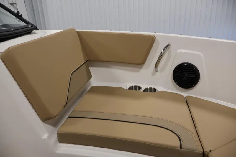 Slide: The Image of 2026 Bayliner V20i boat interior with tan seating, cup holders, and speaker. - 12