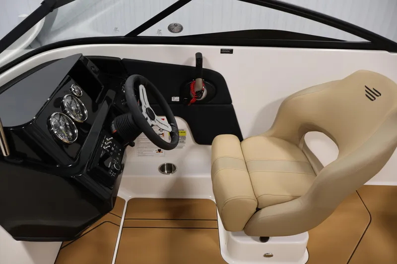 Slide: The Image of 2026 Bayliner V20i boat interior with steering wheel and beige captain's chair. - 16