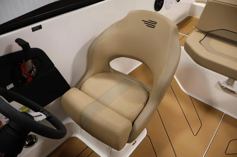 Slide: The Image of 2026 Bayliner V20i boat interior with beige captain's seat and steering wheel. - 24