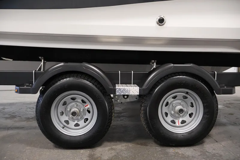 Slide: The Image of Trailer wheels of a 2026 Bayliner V20i boat, parked indoors. - 37