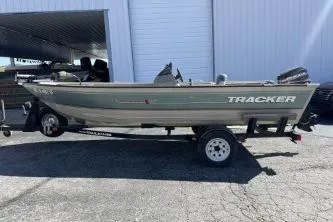 The Image of 2002 Tracker Pro Angler V 16 boat on trailer, parked outside a building. - 1