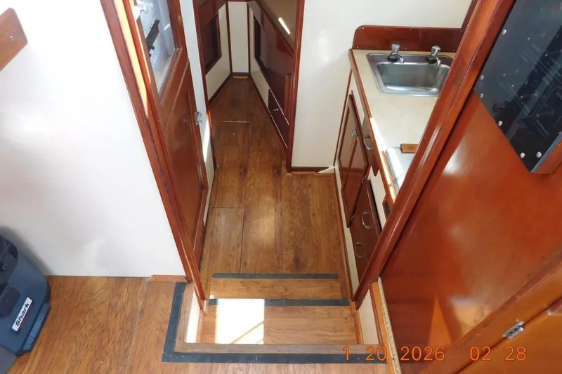 Slide: The Image of Steps down to galley, head, and berth. Laminate wood flooring. - 13