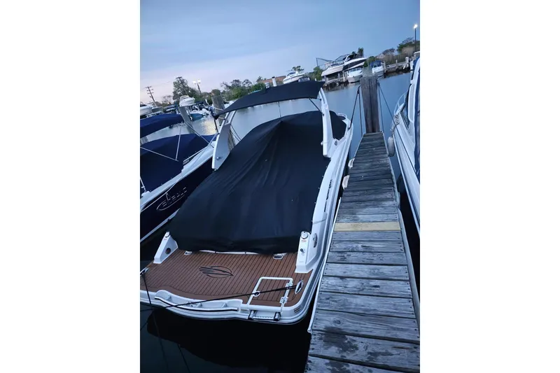 Slide: The Image of 2017 Chaparral 257 SSX boat docked with cover, wooden deck visible. - 2