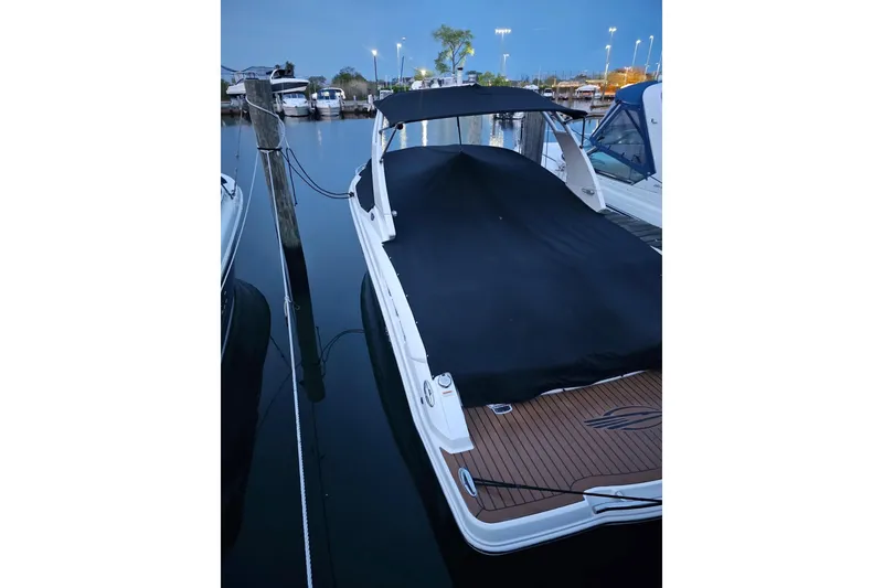 Slide: The Image of 2017 Chaparral 257 SSX boat docked with cover, evening setting. - 3