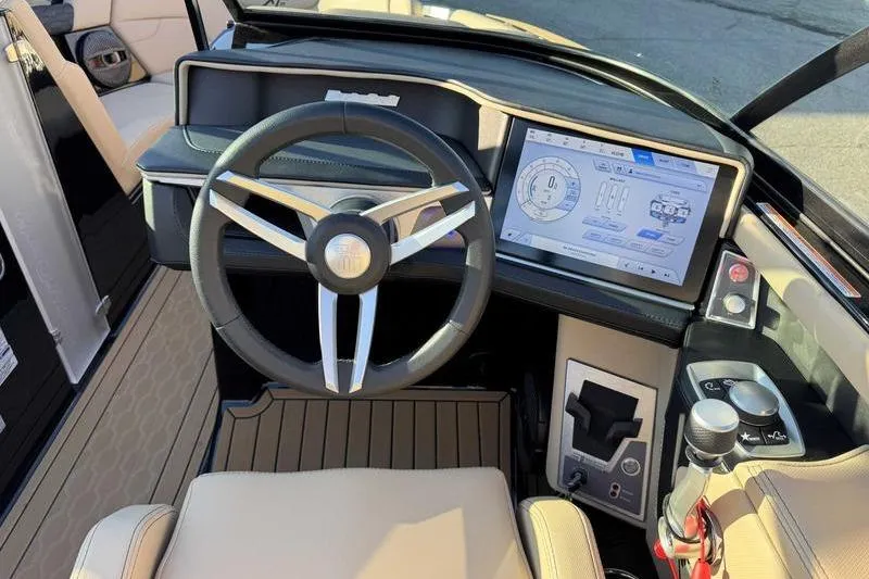 Slide: The Image of 2025 MasterCraft XT23 boat dashboard with modern steering and touchscreen controls. - 14