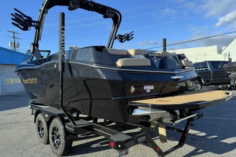 Slide: The Image of 2025 MasterCraft XT23 boat on trailer, black exterior, parked outdoors. - 3
