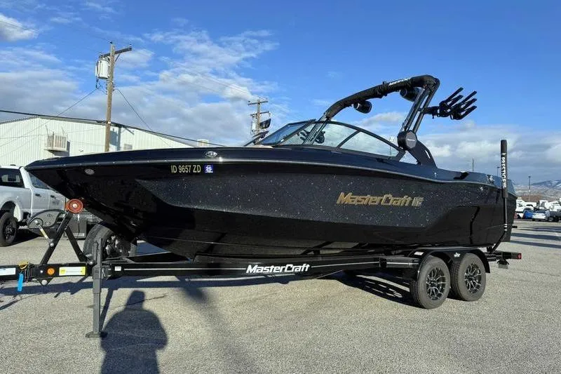 Slide: The Image of 2025 MasterCraft XT23 boat on trailer, sleek black design, parked outdoors. - 6