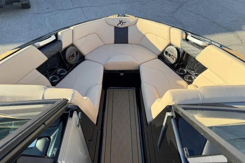 Slide: The Image of 2025 MasterCraft XT23 boat interior with beige seating and cup holders. - 7