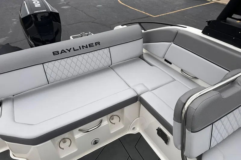 Slide: The Image of 2026 Bayliner D22 boat interior with gray cushioned seating and Mercury outboard motor. - 22