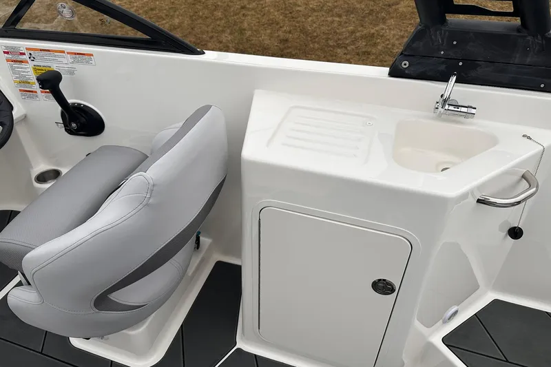 Slide: The Image of 2026 Bayliner D22 boat interior with helm seat and compact sink area. - 26
