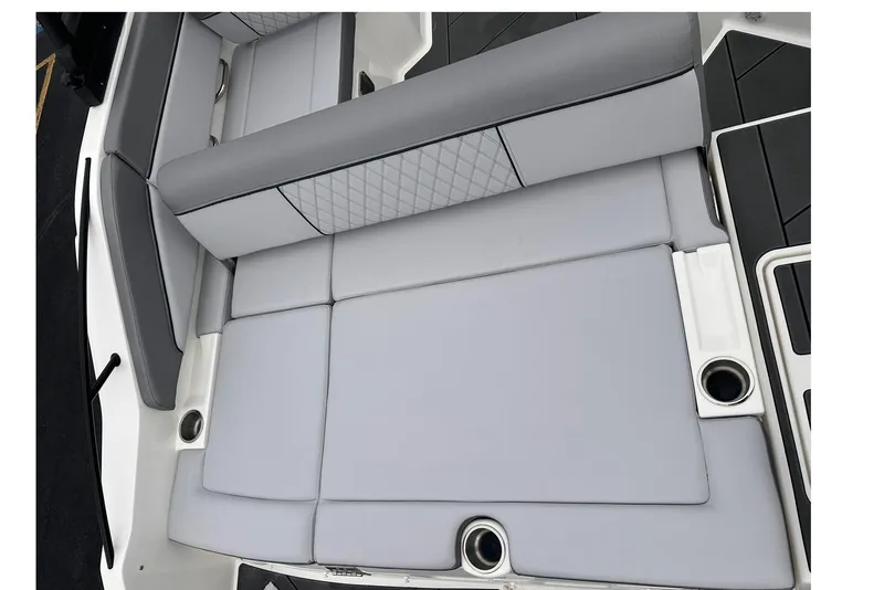 Slide: The Image of 2026 Bayliner D22 boat interior with gray cushioned seating and cup holders. - 27